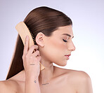 Hair care, beauty and face of woman with brush in studio isolated on a gray background. Eyes closed, eco friendly and female model with sustainable wooden hairbrush for salon treatment or hairstyle.