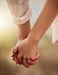 Love, romance and couple holding hands at sunset for bonding, quality time and romantic anniversary. Dating, honeymoon and zoom of man and woman for trust on holiday, vacation and valentines day