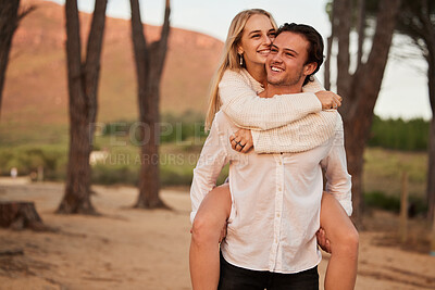 Buy stock photo Happy, love and sunset with couple and piggyback in nature for romance, affectionate and bonding. Happiness, relax and smile with man carrying woman on date for vacation, cute and sweet relationship