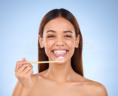 Buy stock photo Toothbrush, portrait and dental with a woman in studio on a blue background for oral hygiene. Mouth, dentist and cleaning with an attractive young female brushing her teeth for healthy gums