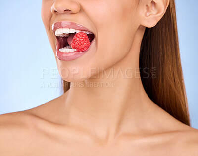 Buy stock photo Mouth, beauty and strawberry with a model woman in studio on a blue background closeup biting a fruit. Food, health and nutrition with a female eating a berry for antioxidants or diet benefits