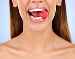 Woman, mouth and raspberry for skincare nutrition, dermatology or diet health plan against a studio background. Female lips with fruit for natural organic food, self care or love for healthy wellness