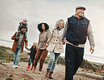 Family holding hands, hiking outdoor together in nature and happiness, bonding and spending quality time. Grandparents, parents and children walking, love and care with happy people and generations