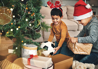 Buy stock photo Festive, happy and children with christmas gifts opening boxes by the tree for celebration. Happiness, holiday and kid siblings with presents in the living room to celebrate xmas at their family home