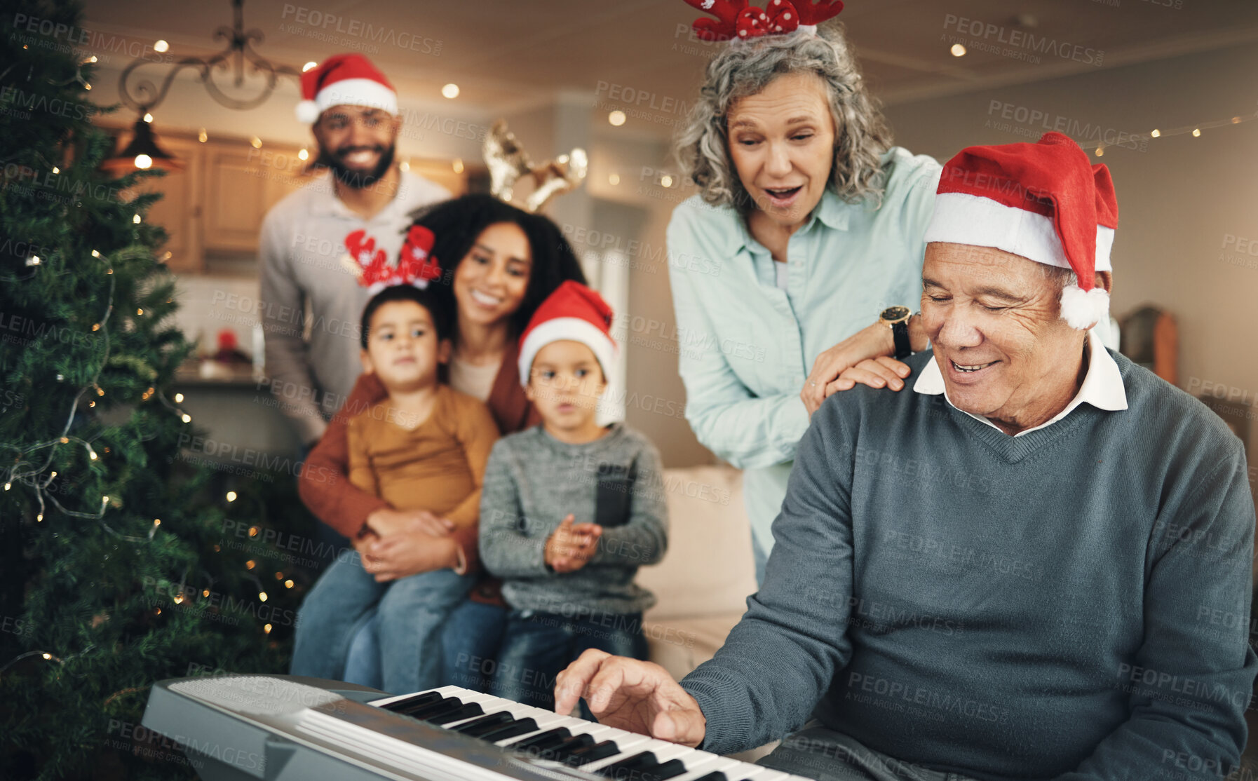 Buy stock photo Family, christmas and senior man with piano in a living room for celebration, song and bond in their home. Music, instrument and retired pianist performing for kids and parents in festive celebration