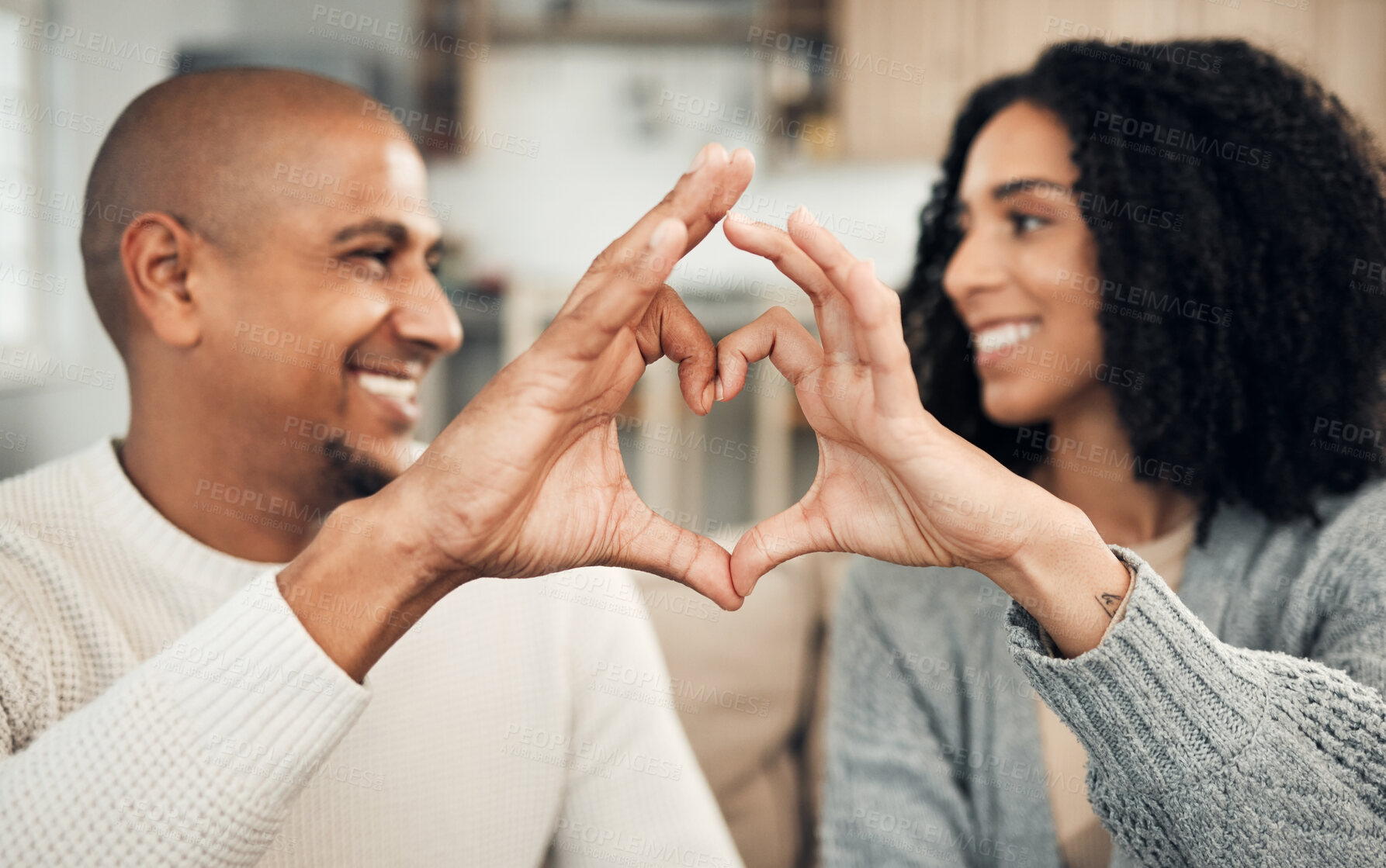 Buy stock photo Love, happy and hand heart by couple on sofa with love, care and trust at home together. Emoji, shape and man with woman hands in support of hope, marriage and unity, smile and joy in living room