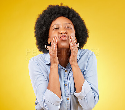 Buy stock photo Happy, blow kiss and black woman in a studio for love, romance or flirting face gesture. Happiness, sensual and African female model with a romantic kissing facial expression by a yellow background.