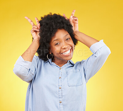 Buy stock photo Goofy, happy and portrait of a black woman in a studio with a silly, funny and comic gesture. Happiness, smile and African female model with peace sign for bunny ears on her head by yellow background