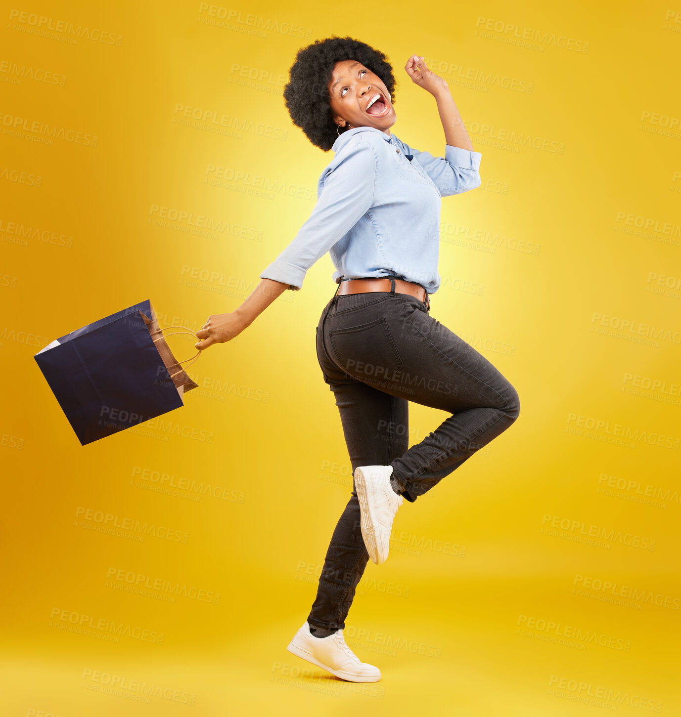 Buy stock photo Bag, happy and black woman shopping, excited and celebrating sale in studio on yellow background. Discount, shopper and girl customer cheerful after boutique, retail or store deal posing isolated