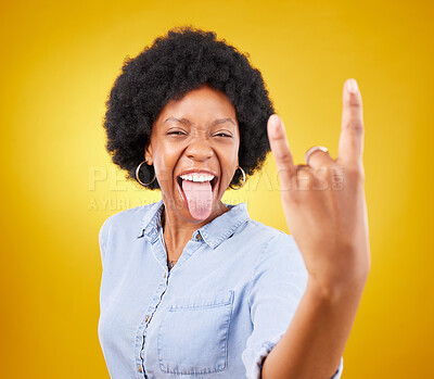 Buy stock photo Rock hand, metal and black woman portrait in studio with tongue out for punk music. Happiness, freedom and cool young female with isolated yellow background feeling edgy with rocker hands sign