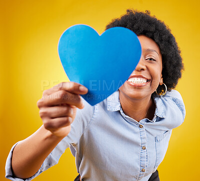 Buy stock photo Paper, heart and happy with black woman in studio for romance, positive and emotion. Happiness, love shape and giving with female isolated on yellow background for date, feelings and affectionate