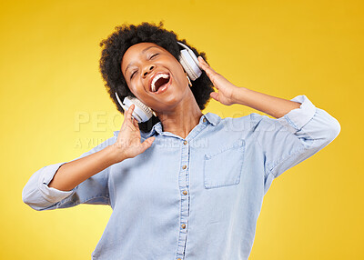 Buy stock photo Black woman, headphones and freedom, listening to music and happiness with dance on yellow studio background. Happy female, carefree and sing along to radio, audio streaming with fun and technology