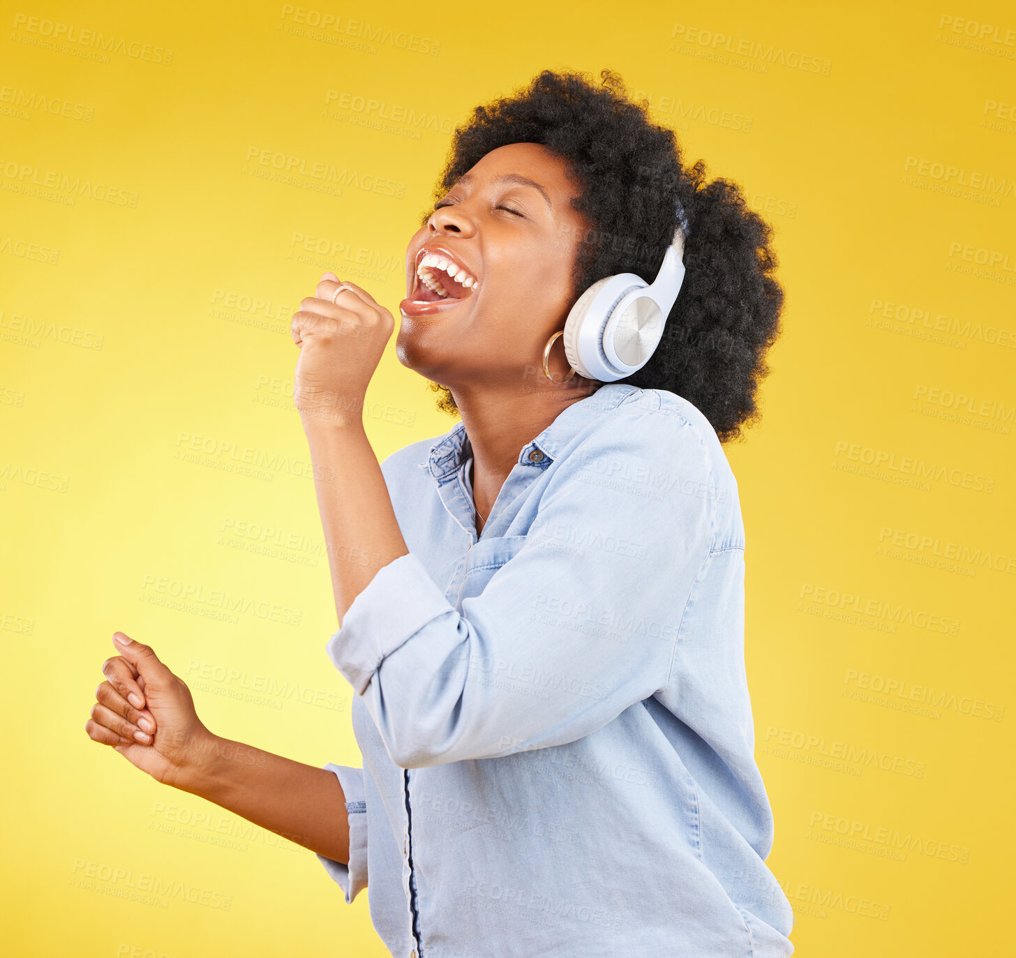 Buy stock photo Black woman, singing with headphones and freedom, music and happiness with invisible mic on yellow studio background. Happy female, carefree and radio, audio streaming, fun and energy with technology