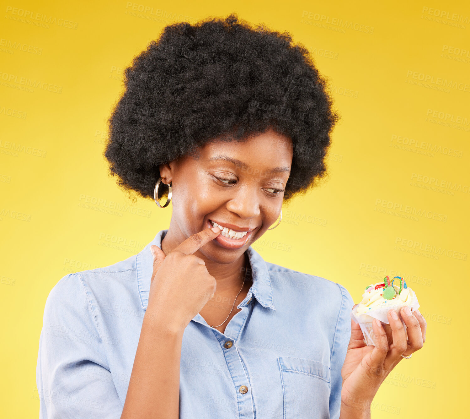 Buy stock photo Woman, cupcake and studio with thinking, diet and temptation for guilt with junk food by yellow background. African model, cake and choice for unhealthy, nutrition and sweets with discipline for meal