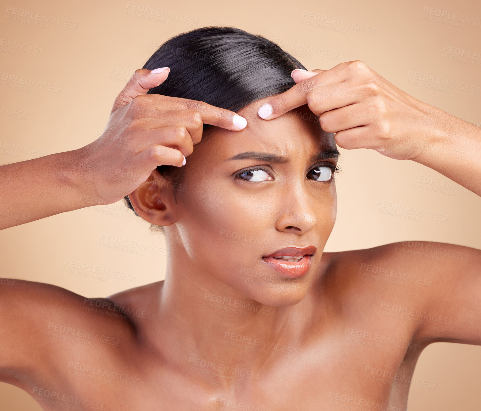 Buy stock photo Indian woman, pimple and skincare in studio with face, cosmetics and stress by background. Model girl, young asian and hand on forehead for cosmetic wellness with worry, skin acne or facial aesthetic