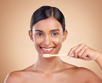 Buy stock photo Portrait, dental and toothbrush with a model woman in studio on a beige background to promote oral hygiene. Face, mouth and dentist up with an attractive young female cleaning or brushing her teeth