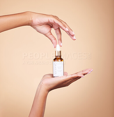 Buy stock photo Hands, product and antiaging serum with a woman in studio on a beige background to promote skincare. Marketing, advertising and luxury with a female holding a bottle for the promotion of beauty