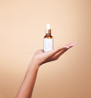 Buy stock photo Hand, product and antiaging serum with a woman in studio on a beige background to promote skincare. Marketing, advertising and luxury with a female holding a bottle for the promotion of beauty