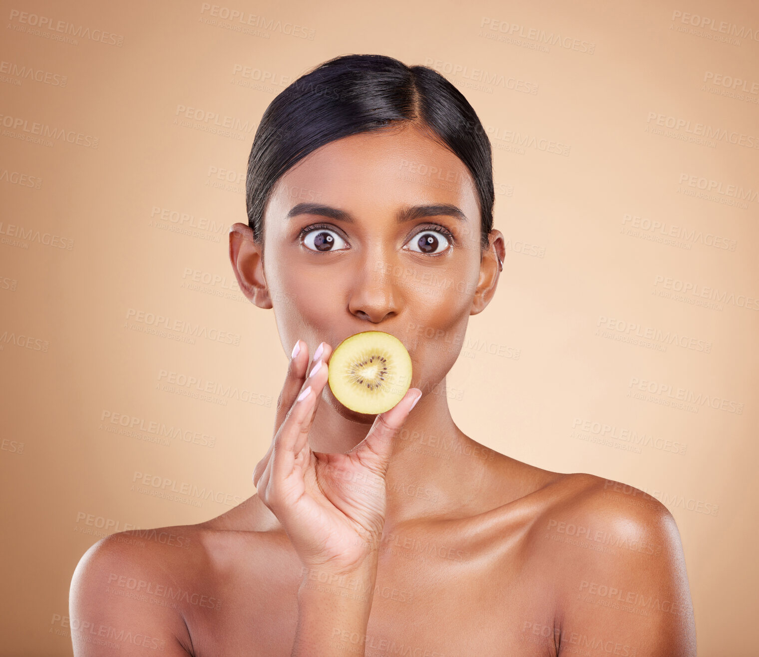 Buy stock photo Wow, beauty or woman with kiwi for healthy detox, skincare or facial treatment routine in headshot. Food nutrition, face or crazy Indian girl with wellness or fruits isolated on studio background