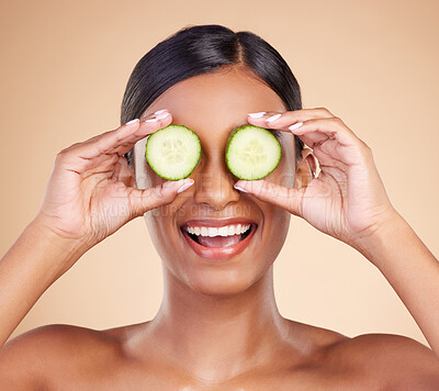 Buy stock photo Woman, face and cucumber for natural skincare, beauty and nutrition cosmetics against a studio background. Happy female holding vegetables with smile for healthy organic facial, diet or spa treatment