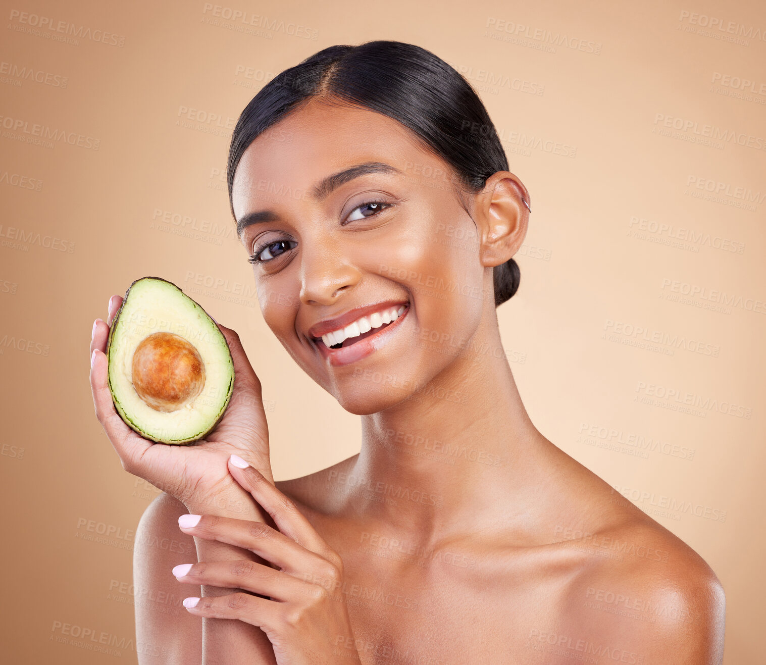 Buy stock photo Portrait, beauty and avocado with a woman in studio on a beige background to promote skincare. Face, fruit and antioxidants with an attractive young female posing for organic or natural cosmetics