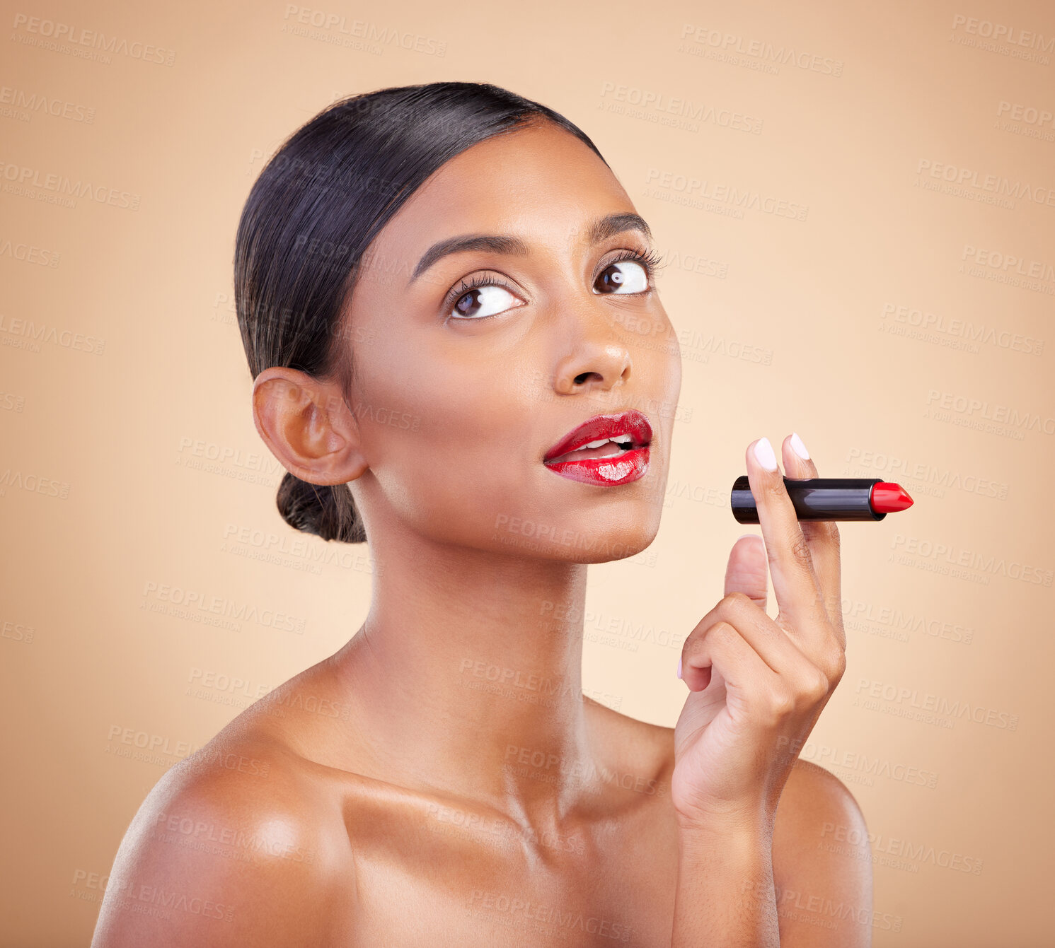 Buy stock photo Beauty, red lipstick and makeup on a woman in studio for cosmetics, skin glow and shine product. Indian female model thinking on beige background for skincare, facial self care and lips with color