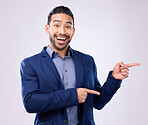 Happy, portrait and man in a studio pointing to mockup for marketing, advertising or product placement. Happiness, smile and male model from India with showing gesture for mock up by gray background.