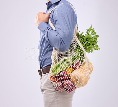 Buy stock photo Diet, groceries and man with vegetables in studio for a healthy, vegan and wellness lifestyle. Health, nutrition and closeup of male model with bag of crops or food to cook dinner by gray background.