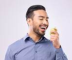 Hungry, eating and an Asian man with an apple isolated on a white background in a studio. Health, food and a Japanese male with fruit for nutrition, diet or hunger during lunch on a backdrop