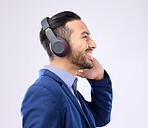 Business, happy man and thinking with music headphones, studio or background of happiness. Smile, young worker and listening to radio, sound and corporate podcast of audio, motivation and inspiration