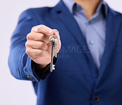 Buy stock photo Realtor, keys and studio closeup of hands for man, new home or property by gray background. Businessman, real estate agent and entrepreneur for buying building, apartment and goals with key at job