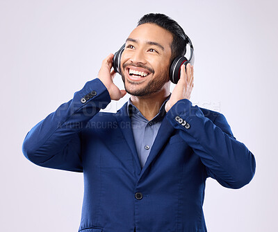 Buy stock photo Executive man, music headphones and thinking on studio background of happiness, motivation and inspiration. Happy corporate worker listening to audio, sound and business podcast on radio with smile 