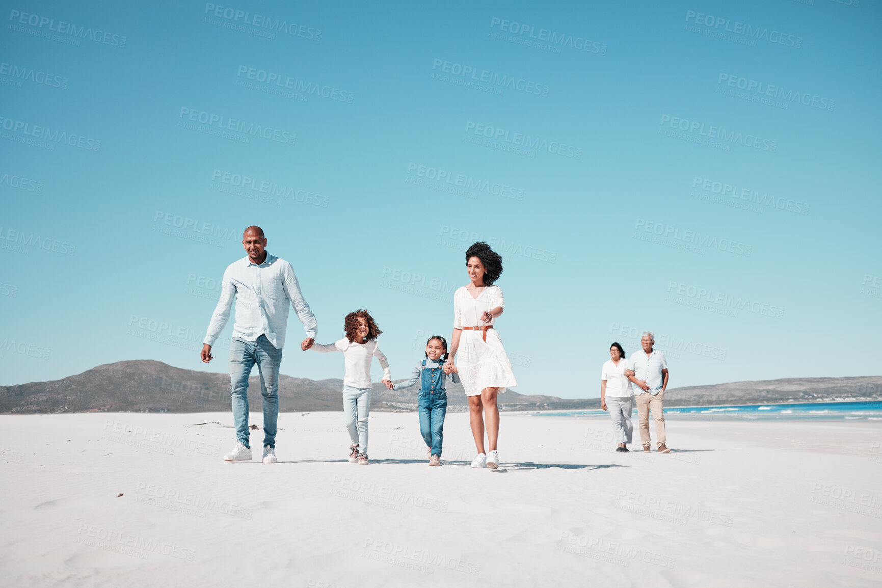 Buy stock photo Holding hands, family and children walking on beach to relax on summer holiday, vacation and weekend. Travel, blue sky and grandparents, parents and kids by ocean for fun, bonding and quality time