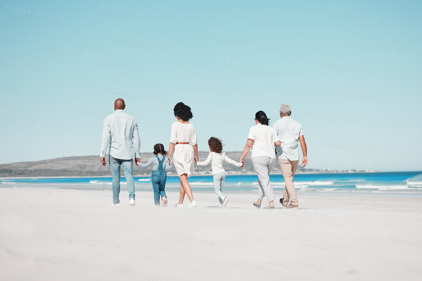 Buy stock photo Grandparents, parents and children on beach walking to relax on summer holiday, vacation and weekend. Blue sky, travel and back of big family holding hands for bonding, quality time and calm by ocean