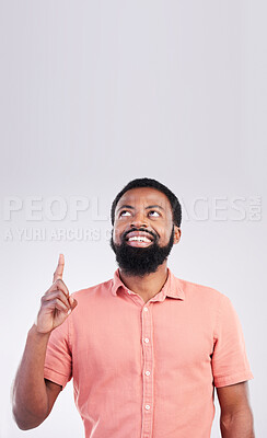 Buy stock photo Point, mockup space and black man looking up with hand gesture for product placement, advertising and sign. Happy, studio and male smile on white background pointing for choice, branding and showing