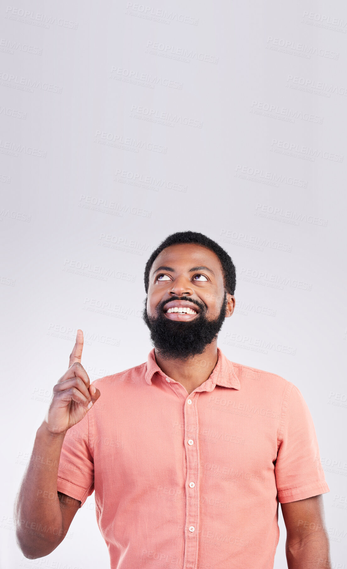 Buy stock photo Point, mockup space and black man looking up with hand gesture for product placement, advertising and sign. Happy, studio and male smile on white background pointing for choice, branding and showing