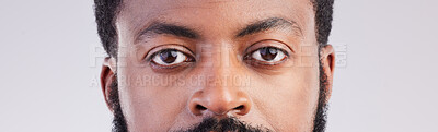 Buy stock photo Black man, eyes and face portrait in studio for vision, focus and serious expression to stare. African male person on a grey background for eyesight, determination and awareness of unique identity