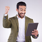 Success, winning and man on tablet isolated on studio background fist pump for business news or online bonus. Happy asian person or winner on digital tech with celebration for sale, prize or giveaway