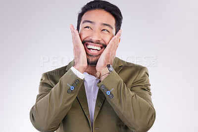 Buy stock photo Excited, thinking and Asian man with smile, success and profit growth against a grey studio background. Japan, male employee and entrepreneur with hands on face, winner and victory with happiness