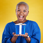 Excited, portrait and black woman with birthday gift in studio isolated on a yellow background. Face, box and happy African female with present for celebration, party and holiday for special event. 
