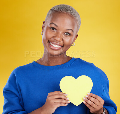 Buy stock photo Paper heart, portrait and happy black woman in studio, background and color backdrop. Smile, female model and yellow shape for love, wellness and caring support of peace, romance and sign of kindness