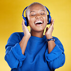 Music, headphones and black woman singing in studio isolated on a yellow background. Podcast, radio singer and happy African female streaming, enjoying and listening to audio, sound track or song.