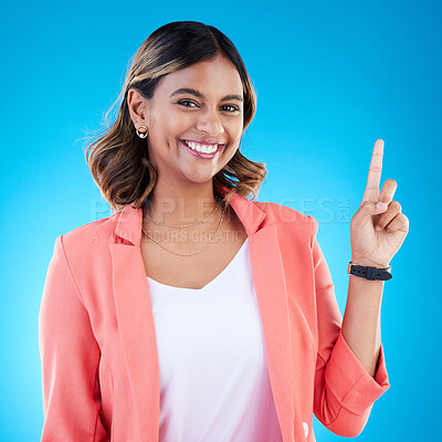 Buy stock photo Smile, portrait and Indian woman in studio pointing up for product placement, mockup or information. Deal, promotion or announcement, happy model showing info space or notification on blue background