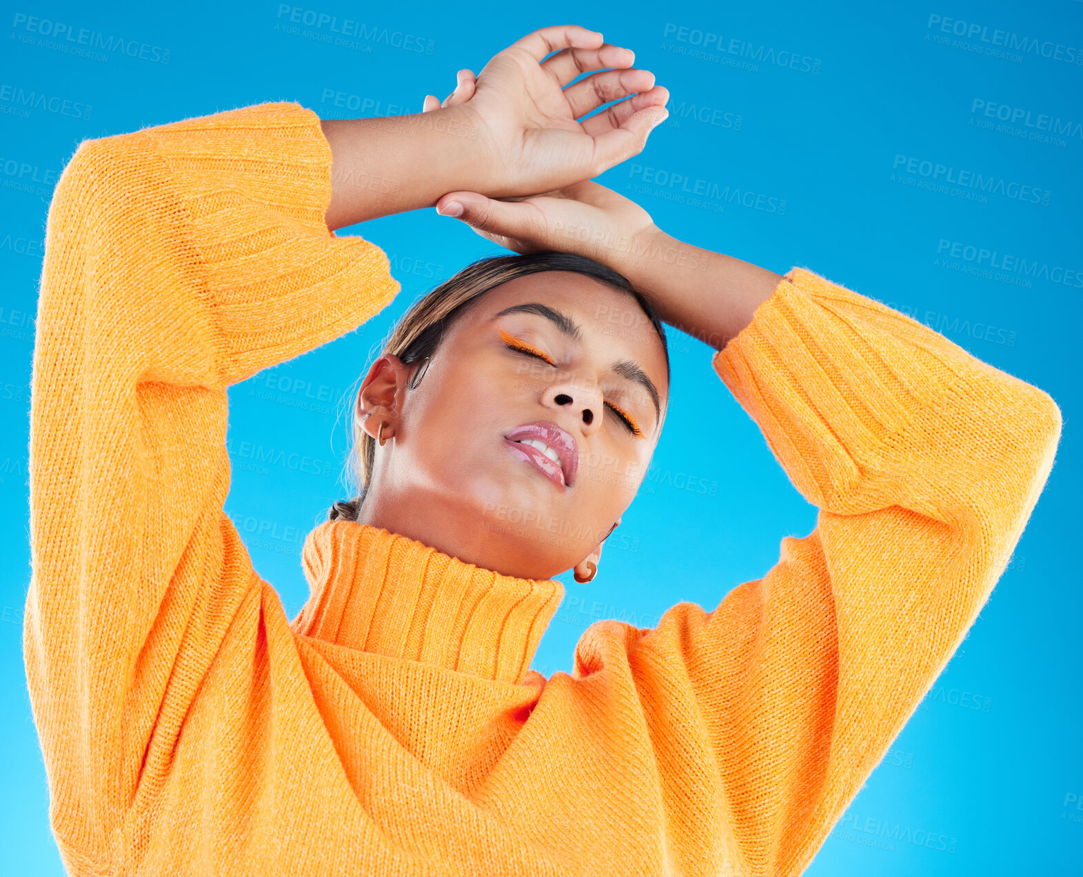 Buy stock photo Woman, makeup and fashion aesthetic of a young female with cosmetics in a studio. Posing, gen z and stylish person with youth and colorful eyeliner with isolated and blue background feeling cool