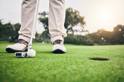 Golf, feet and player hit ball and professional athlete training and putting on a filed as exercise or workout. Sportsman, equipment and gentleman golfer or person relax and playing a sport