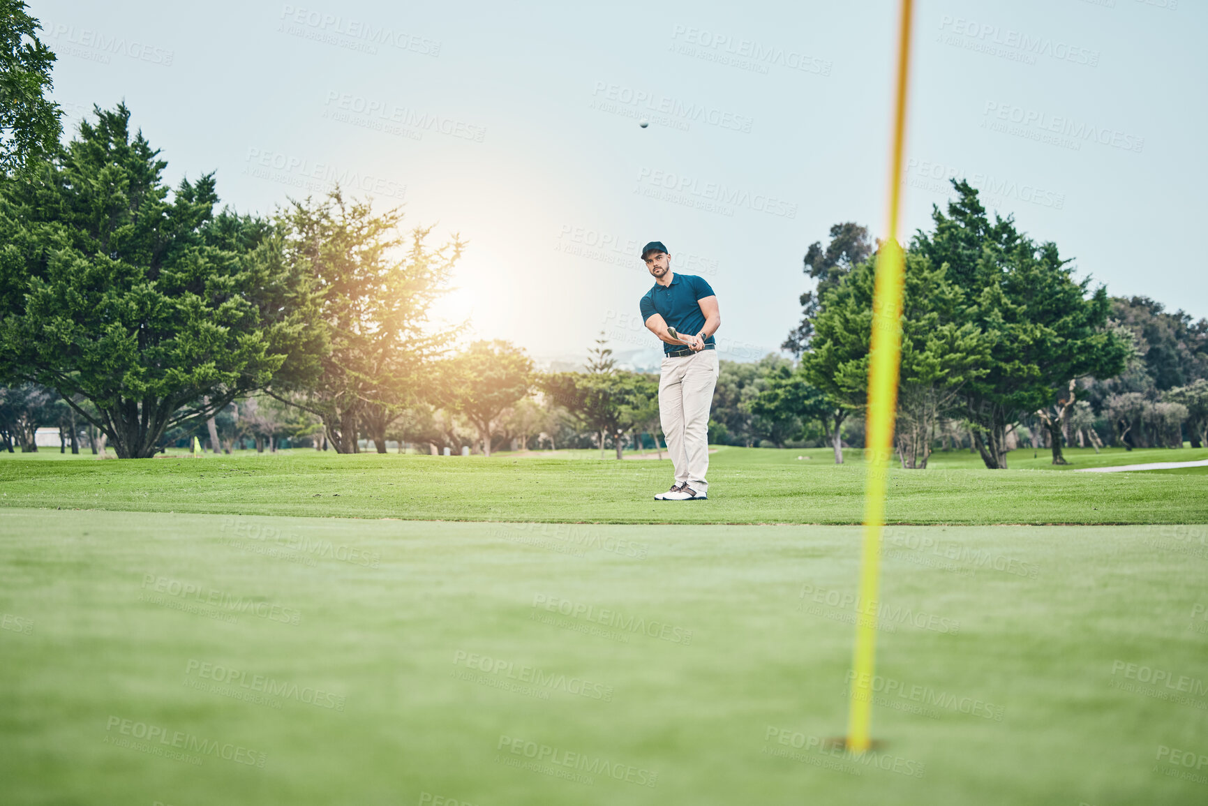 Buy stock photo Grass, golf hole and man with golfing club on course for game, practice and training for competition. Professional golfer, sports and male athlete hit ball with club for winning, score or tee stroke