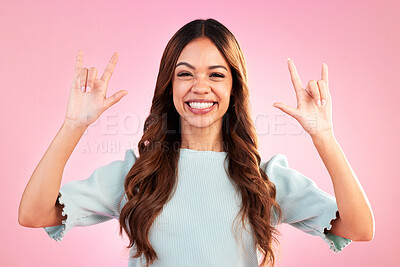 Buy stock photo Portrait of woman, smile and rock hand gesture in studio, happy expression on face on pink background. Culture, hispanic model and hands in devil horn sign or emoji, punk attitude and happy symbol.