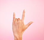 Sign language, funky and hand with a gesture for rock isolated on a pink background in a studio. Celebrate, deaf communication and person gesturing for metal music, emoji and expression on a backdrop