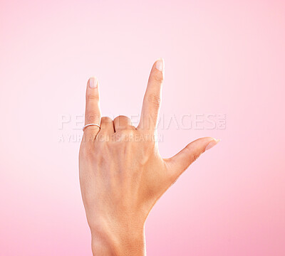 Buy stock photo Sign language, funky and hand with a gesture for rock isolated on a pink background in a studio. Celebrate, deaf communication and person gesturing for metal music, emoji and expression on a backdrop