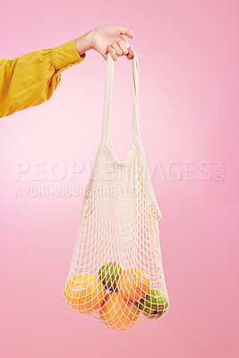 Buy stock photo Hand, shopping and bag with fruit in studio by pink background for diet, health and deal in recycle material. Grocery discount, fruits or vegetables from store for food, sustainability and lifestyle